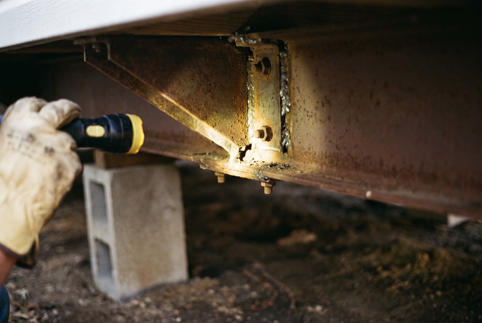 A flashlight on the welded steel frame under a manufactured home